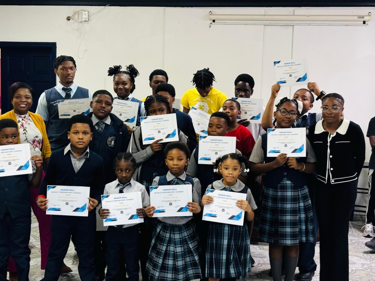 RPA students of different ages holding their honour-roll certificates together.