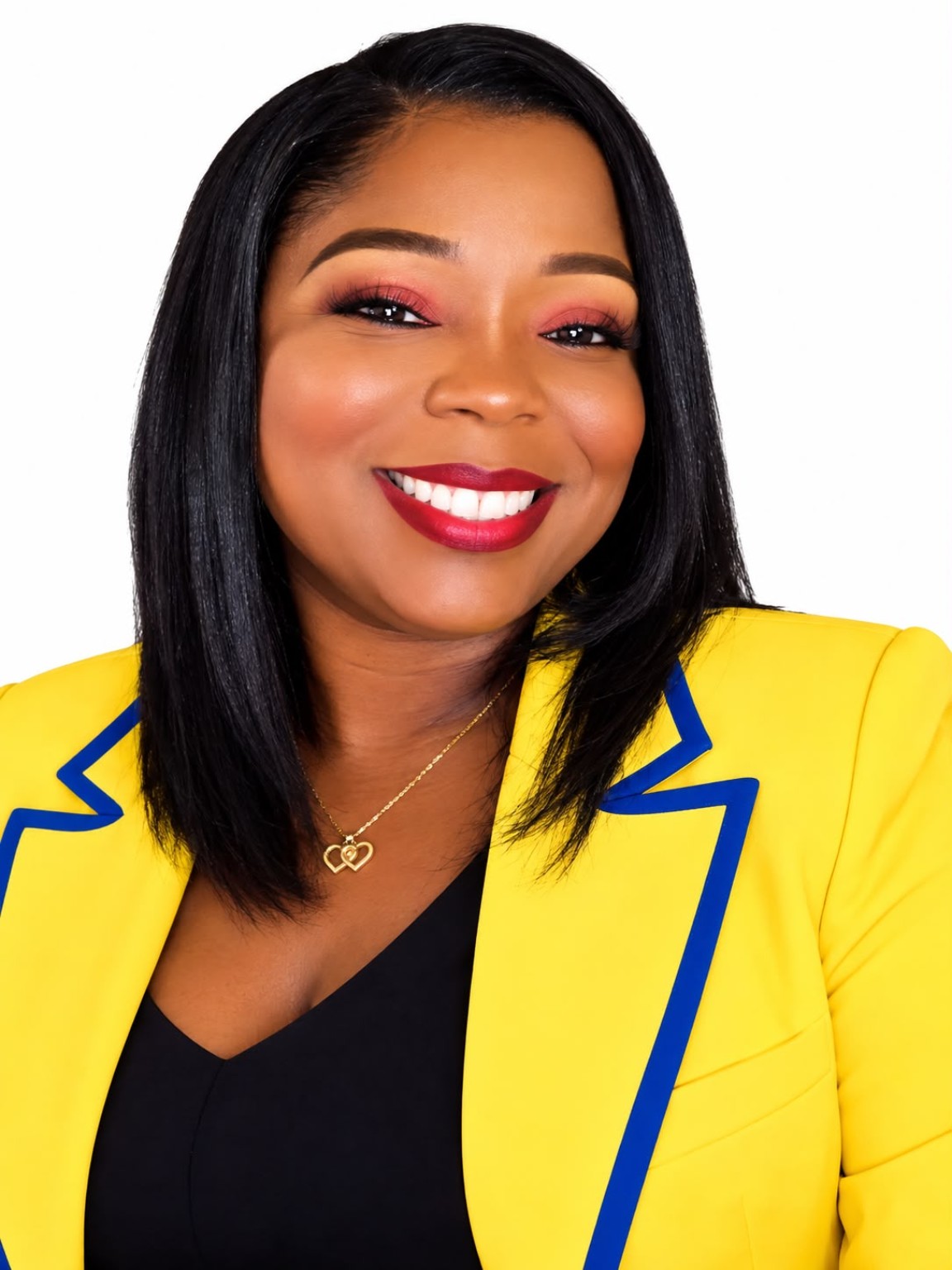 Evelyn Bethel, principal of Royalty Preparatory Academy, smiling in a yellow jacket with navy trim.